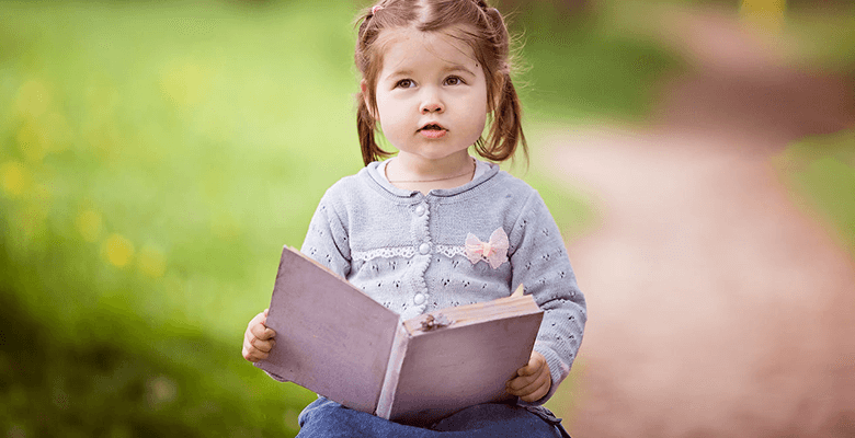 طفلة صغيرة تقرأ.