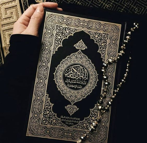 فتاة تمسك بالمصحف الكريم.